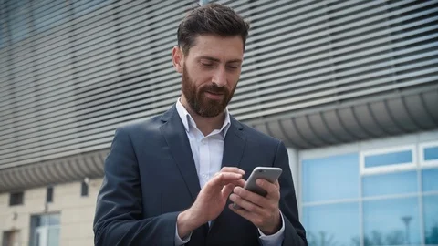 CloseUp of Attractive Young Businessman using his Smartphone and Smiles.  Stock Footage 113276474
