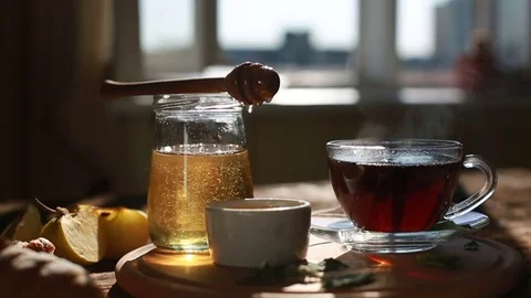 Closeup is authentic honey slowly drains from a spoon. Morning time. Tea Stock Footage 78589701
