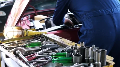 Closeup auto mechanic using wrench from  tool table to tighten bolt. Video stock 119418697