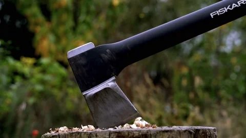 Closeup of axe being removed and chopped into wooden chopping block Stock Footage 220084011