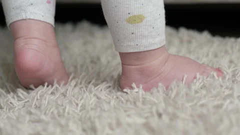Closeup baby first steps on soft carpet Stock Footage 338173336