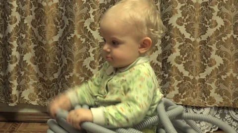 Closeup Baby Girl Sitting in Electrical Corrugated Tube. 4K UltraHD, UHD Stock Footage 61102653