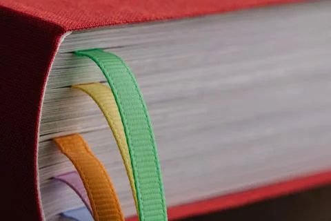 Closeup of the back of a book with colored bookmarks. Stock Photos