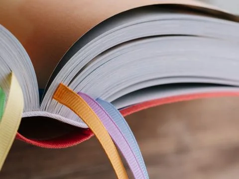 Closeup of the back of a book with colored bookmarks. Stock Photos