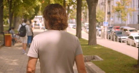 Closeup back view portrait of caucasian man walking in park outdoors Stock Footage 114916459