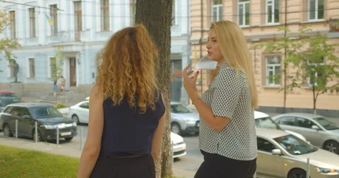 Closeup back view portrait of two female friends walking having conversation in Video stock 114894353