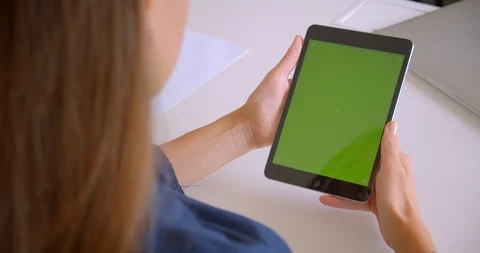 Closeup back view portrait of young attractive caucasian woman tapping on tablet Stock Footage 114185935