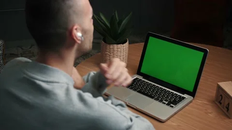 Closeup back view shot of young man having a video call on the laptop with green Stock Footage 144067675