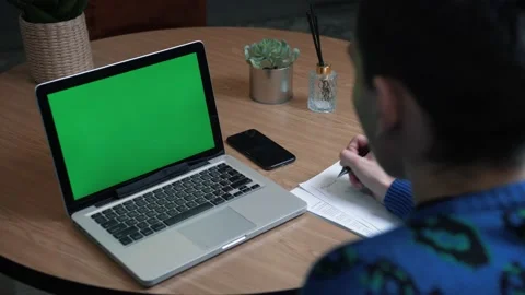 Closeup back view shot of young man having a video call on the laptop with green Stock Footage 144492733