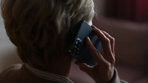 Closeup back view of unrecognizable middle-aged woman answering phone, brings Video stock 255055827