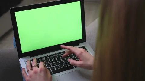 Closeup. Back view of woman working on laptop green screen chromakey on sofa at Stock Footage 150280817