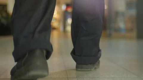 Closeup Backside View Man Walks along Bright Lit Shop Stock Footage 75877028