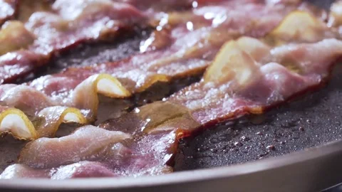 Closeup of bacon strips frying on a grill Video stock 72415560