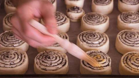 Closeup. Baker covers poppy roll buns before baking. Baking concept. Video stock 101140454
