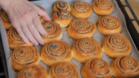 Closeup. Baker shows hot fresh pastries in the bakery. Video stock 101139644