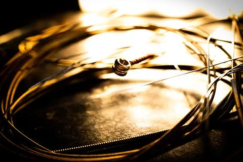Closeup of Ball End on Guitar String Surrounded by Circle of Used Loose Guita Foto stock