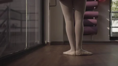 Closeup of Ballet Dancer Warming Up Indoors Before Dance Practice Session Stock Footage 340231748