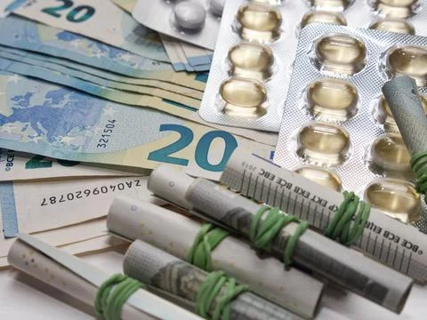 A closeup of banknotes and tablets symbolizing the costs of the healthcare .. Fotos de archivo