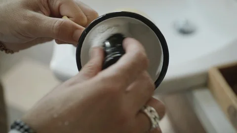 Closeup of barber using a brush to make shaving foam in a mug. Video stock 117683327