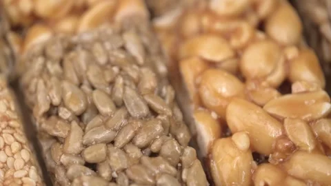 Closeup of bars made of sesame, peanuts and sunflower seeds in caramel. rotation Stock Footage 247428803