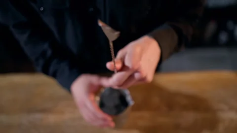 Closeup of a bartender demonstrating barspoon stirring technique above a Stock Footage 318651889