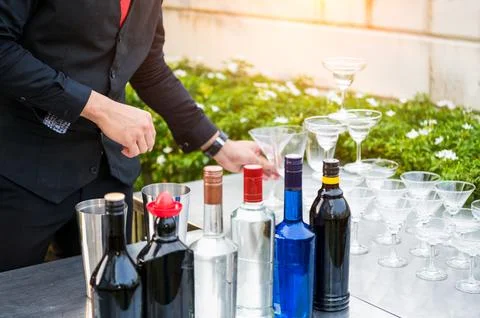 Closeup bartender hand preparing fresh juice cocktail in drinking wine glas.. Photos