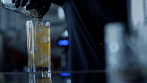 Closeup bartender hands pouring cocktail in glass. Mixologist preparing beverage Video stock 206119428