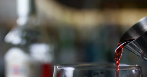 Closeup of bartender pouring gin into the mixing glass to prepare a negroni Stock Footage 106469025
