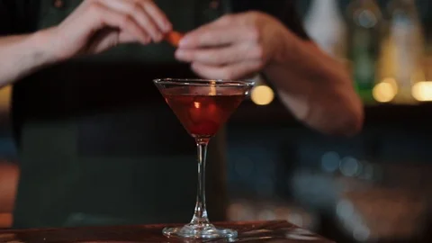 Closeup of a bartender squeezes oranges juice while preparing an alcoholic Stock Footage 126637473