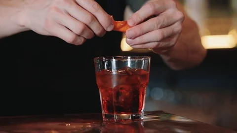 Closeup of a bartender squeezes oranges juice while preparing an alcoholic Video stock 129110986