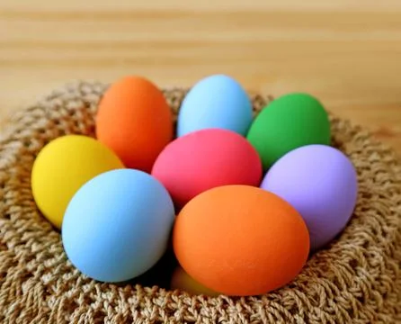 Closeup a Basket of Multi-color Easter Eggs on Wooden Table Stock Photos