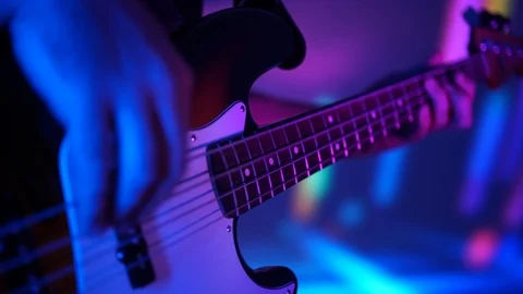 Closeup of bass player hands playing music with bass guitar at the concert in Stock Footage 99691917