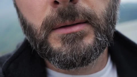 A closeup of a bearded man using a heated tobacco device Vidéo 288520286