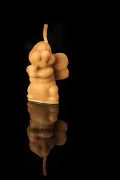 Closeup bee shape wax candle stands on black background Stock Photos
