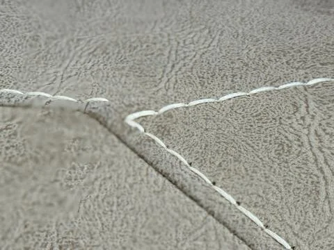 Closeup of beige leather texture with white stitching, ideal for background.. Stock Photos