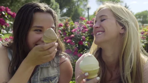 Closeup Of Best Friends Eating Ice Cream Cones, They Smile And Hug Stock Footage