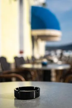 Closeup of a black ash tray on the table of a coffee shop Stock Photos
