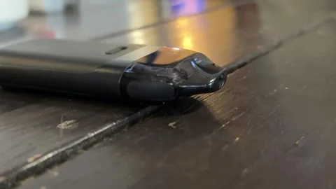 Closeup of black vape device resting on worn wooden tabletop, showing compa.. Stock Footage 348136592