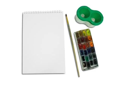 Closeup of blank spiral notepad surrounded with watercolor paint, glass of .. Fotos Stock
