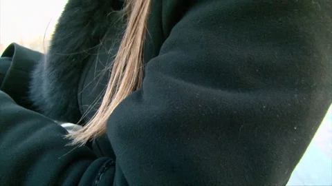 Closeup blond hairs on black jacket on wind, coat with a fur, winter Video stock 72284162