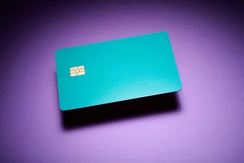 Closeup of a blue debit card with a microchip on a purple table Stock Photos