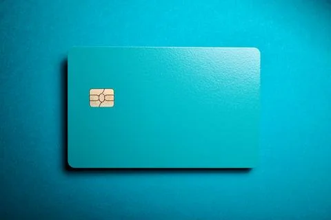 Closeup of a blue debit card with a microchip on a blue table Stock Photos