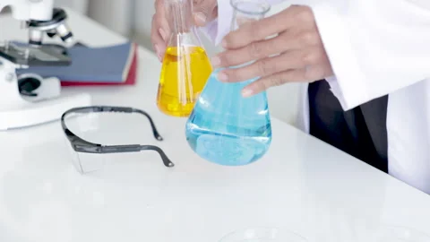 Closeup of blue gloved scientist hand is comparing chemical mixing solution.. Stock Footage 243410502