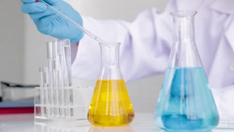 Closeup of blue gloved scientist hand is drop liquid blue and yellow soluti.. Stock-Footage 243414959
