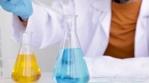 Closeup blue gloved scientist hand is comparing different liquid solution t.. Stock Footage 243415543