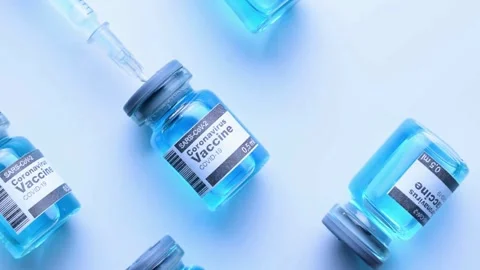 Closeup blue medicine bottle. preparing a vaccine syringe for a shot An Stock-Footage 336587077