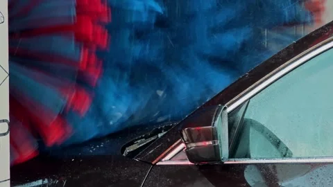 Closeup of blue rotating car wash brushes washing vehicle window. Detailed view Stock Footage 324928486