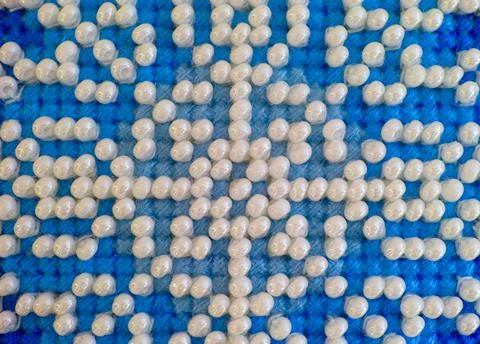 Closeup of Blue threads cross stitch pattern with white beads. 写真素材