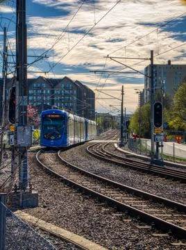 Closeup of a Blue tram approaching on parallel tracks on a lightly cloudy day in 库存照片