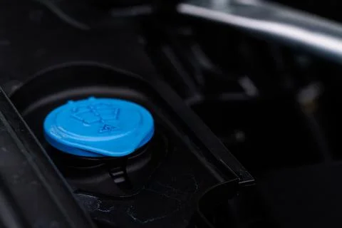 Closeup blue windshield washer fluid reservoir cap in engine room. Liquid cap Stock Photos